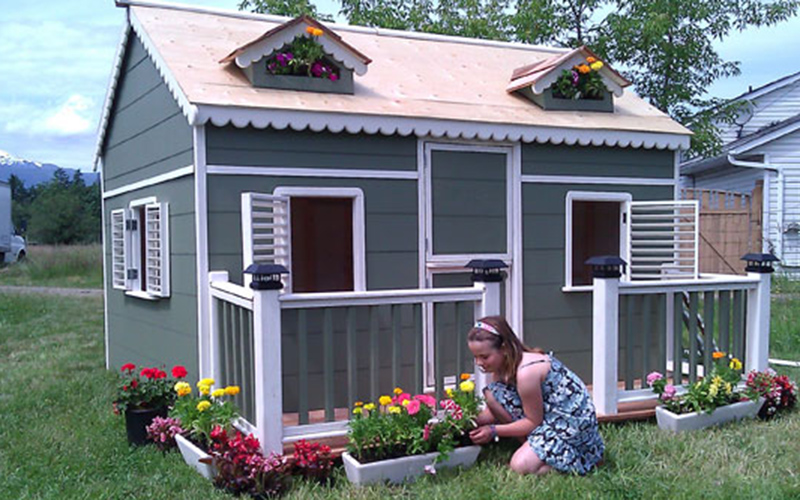 Alexandra in front of her playhouse